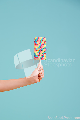 Image of Have a taste..its delicious. A little girls hand holding a hard candy lollipop.