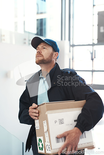 Image of Hes on route to make a delivery. Shot of a handsome delivery man heading up a flight of stairs with a customers order.