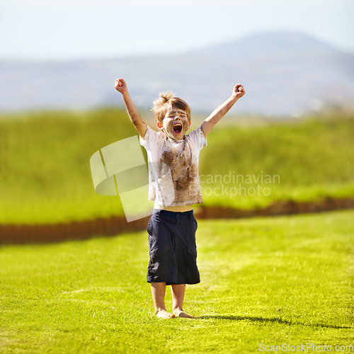 Image of Im the winner. Cute little boy cheering while standing outdoors.