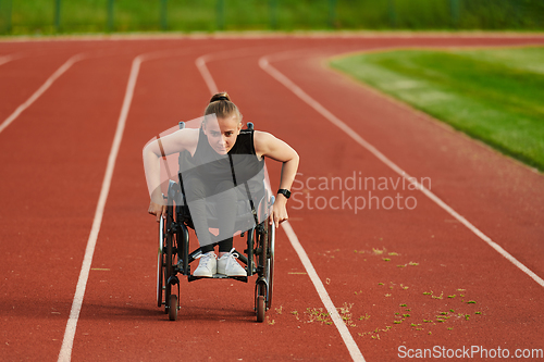 Image of A woman with disablity driving a wheelchair on a track while preparing for the Paralympic Games