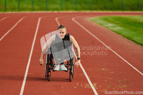 Image of A woman with disablity driving a wheelchair on a track while preparing for the Paralympic Games