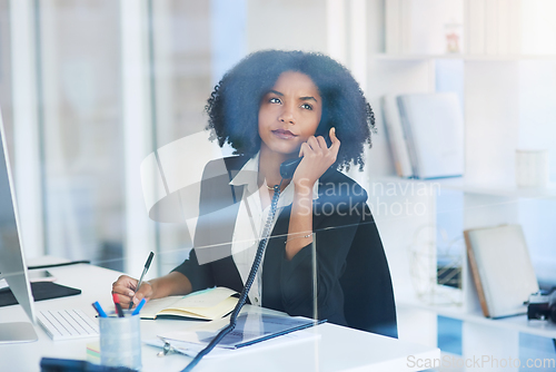 Image of On call with some important clients. Shot of a young businesswoman talking on a telephone in an office.