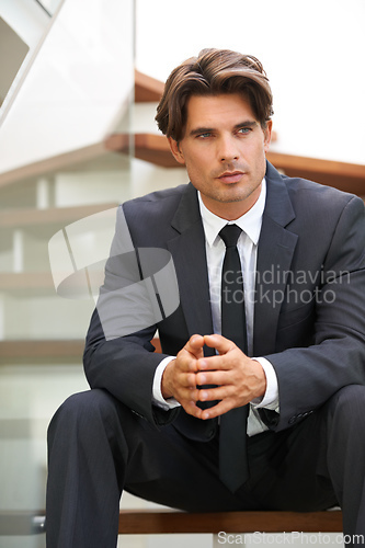 Image of Planning his next business move. A handsome young businessman sitting on the stairs deep in thought.