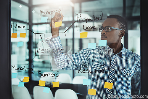 Image of His strategies are bulletproof. Cropped shot of a handsome young businessman working on a glass wipe in the office.