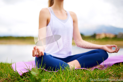 Image of Life is a balance of holding on and letting go. Shot of a young woman doing yoga outdoors.