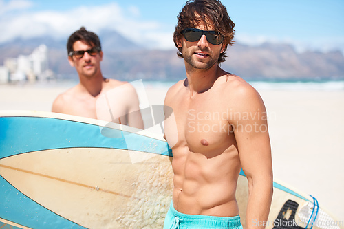 Image of Heading to the water. Two friends at the beach getting ready to head into the water for a surf.