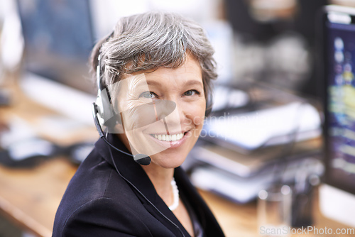 Image of Her clients enjoy her friendly demeanor. Shot of an mature female call center representative wearing a headset.