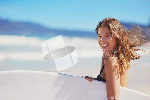 Image of Surfs up. Portrait of a young surfer standing on the beach.