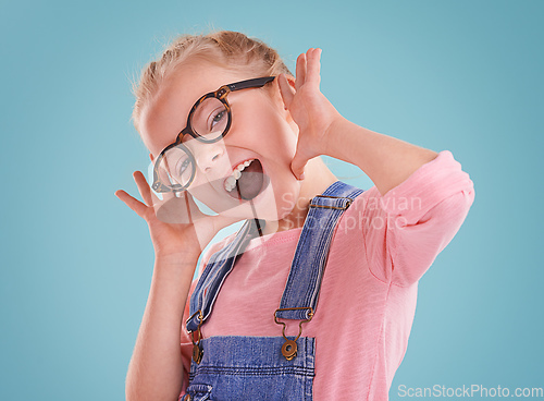 Image of These glasses make me feel cute. Studio shot of a little girl wearing hipster glasses on a blue background.