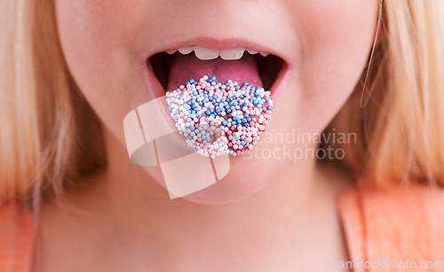 Image of Mmmm, delicious. Cropped closeup of a little girl with candy on her tongue.