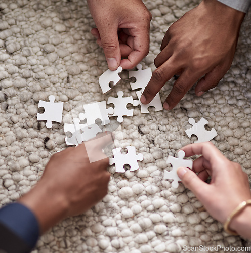 Image of Pulling together to solve a problem. Cropped shot of a group of people fitting puzzle pieces together.