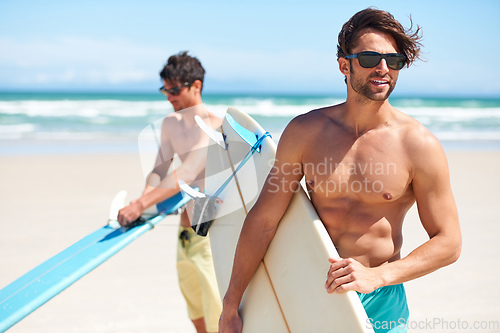 Image of Surfs up. Two friends at the beach getting ready to head into the water for a surf.