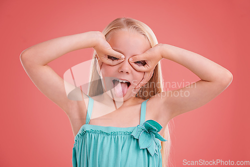 Image of Playing silly. Studio shot of a young girl posing on an orange background.