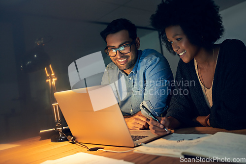 Image of They always perform at their peak no matter the hour. Cropped shot of two colleagues working late on a laptop in an office.