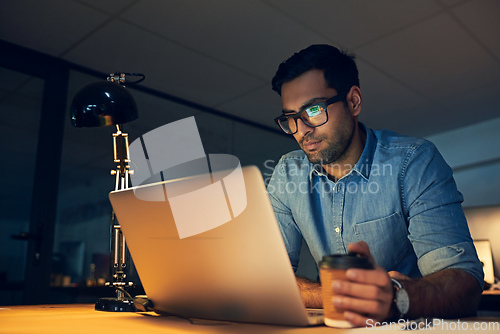 Image of Focused on achieving only the best. Cropped shot of a young businessman working late on a laptop in an office.