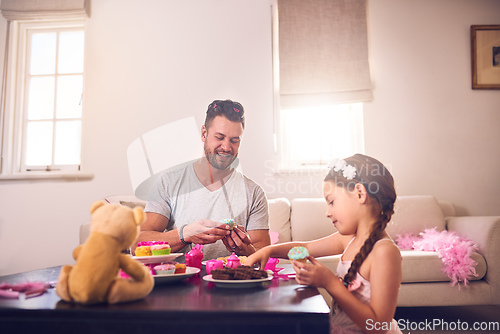 Image of Dad will do anything to make her feel like a princess. Shot of a father and his little daughter having a tea party together at home.