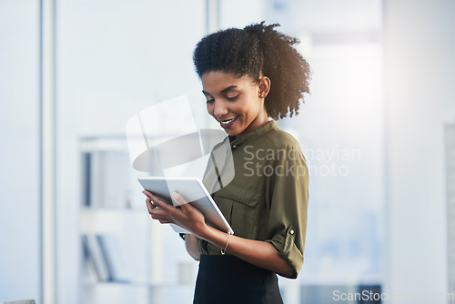 Image of Life made easier with the touch of a button. Shot of a young businesswoman using her digital tablet in a office.