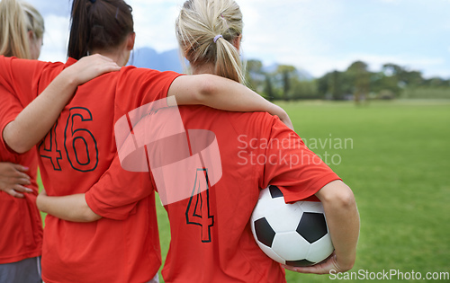 Image of Ready to take on the field. A girls soccer team standing with their arms around each others shoulders looking towards the field.