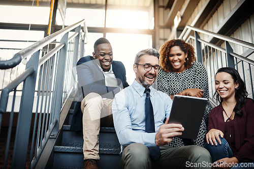 Image of Sometimes spontaneous meetings are the best. Low angle shot of a diverse group of colleagues having an impromptu meeting with a tablet on the stairs.