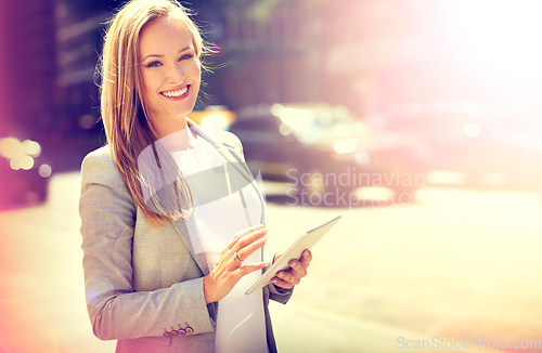 Image of Navigating city life. Portrait of an attractive woman using a digital tablet while walking in the city.