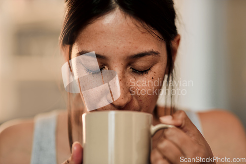 Image of A good day starts with good coffee. Shot of a young woman enjoying a cup of coffee at home.