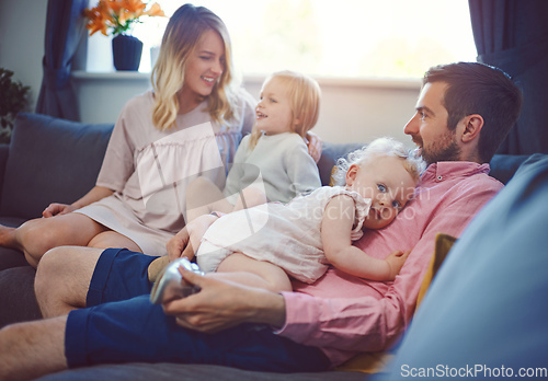 Image of Make time for those you love. Shot of an adorable young family of four relaxing together on the sofa at home.