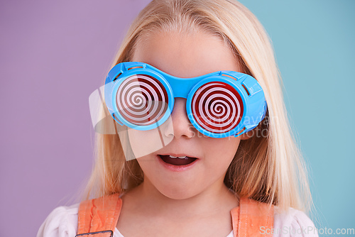 Image of Going crazeeee. A cute little girl wearing funny sunglasses against a colorful background.