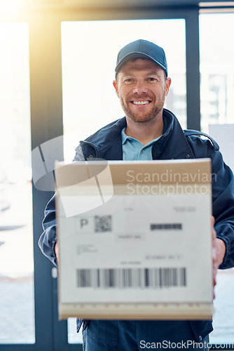 Image of Delivered on time, every time. Cropped portrait of a handsome delivery man waiting in the lobby with a customers order.