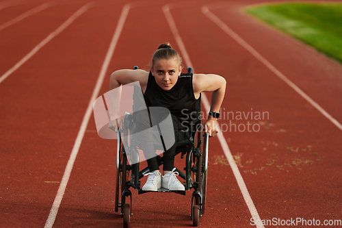 Image of A woman with disablity driving a wheelchair on a track while preparing for the Paralympic Games