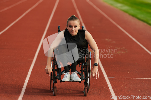 Image of A woman with disablity driving a wheelchair on a track while preparing for the Paralympic Games