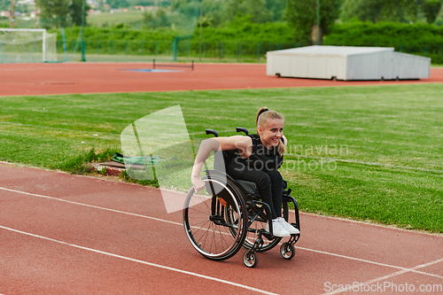 Image of A woman with disablity driving a wheelchair on a track while preparing for the Paralympic Games