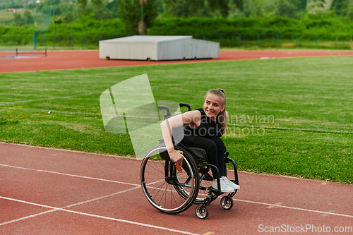 Image of A woman with disablity driving a wheelchair on a track while preparing for the Paralympic Games