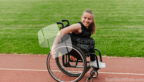 Image of A woman with disablity driving a wheelchair on a track while preparing for the Paralympic Games