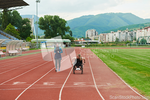 Image of A Muslim woman in a burqa running together with a woman in a wheelchair on the marathon course, preparing for future competitions.