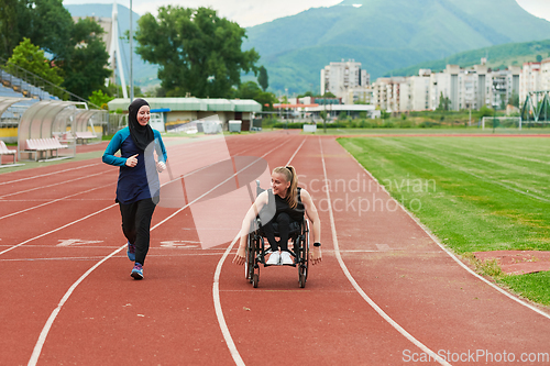 Image of A Muslim woman in a burqa running together with a woman in a wheelchair on the marathon course, preparing for future competitions.