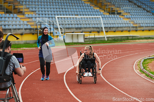 Image of A cameraman filming the participants of the Paralympic race on the marathon course