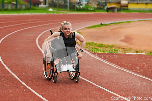 Image of A woman with disablity driving a wheelchair on a track while preparing for the Paralympic Games