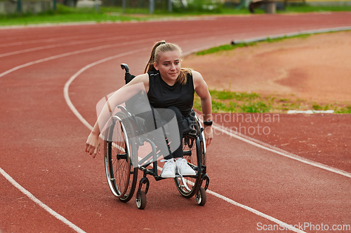 Image of A woman with disablity driving a wheelchair on a track while preparing for the Paralympic Games