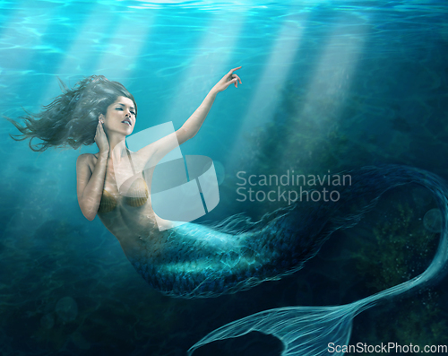 Image of Siren of the sea. Shot of a mermaid swimming in solitude in the deep blue sea - ALL design on this image is created from scratch by Yuri Arcurs team of professionals for this particular photo shoot.