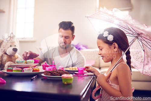 Image of Every great childhood memory includes a royal tea party. Shot of a father and his little daughter having a tea party together at home.