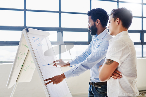 Image of Delving into the details. Cropped shot of two businesspeople brainstorming together in an office.