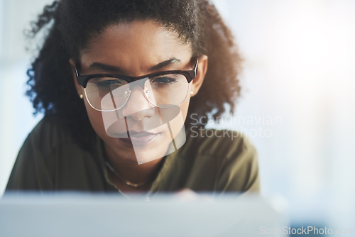 Image of Persistence and hard work are always key in success. Shot of a young businesswoman busy working on her laptop in a modern office.