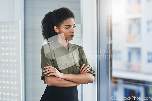 Image of Never let fear or self-doubt cloud your judgment. Shot of a young businesswoman looking out of a window in her office.