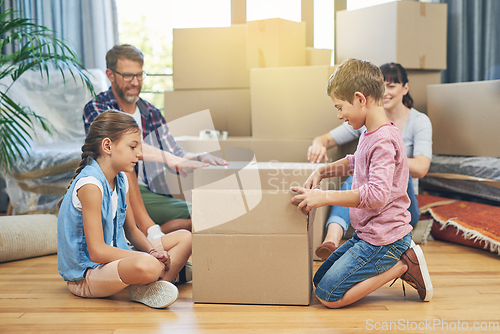 Image of Their familys got moving day covered. Shot of a family of four helping each other pack boxes on moving day.