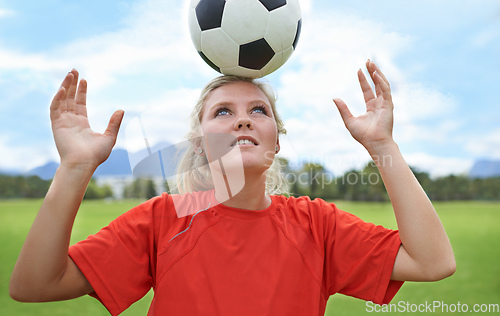Image of Its all about balance. Shot of a young female soccer player balancing a ball on her head.