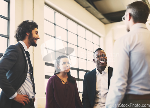 Image of Catching up with the team. Shot of a team of laid-back businesspeople chatting during their break in the office.