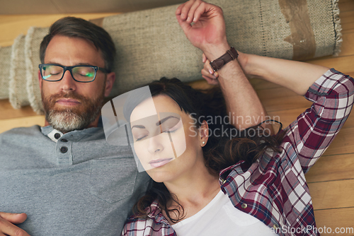 Image of Nestled into their new home. High angle shot of a couple taking a nap together on moving day.