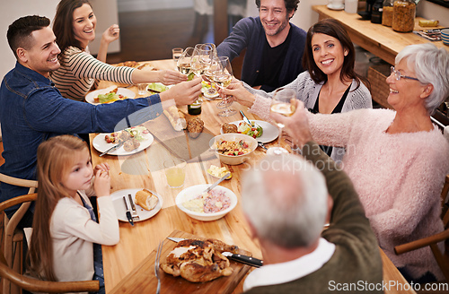 Image of Toasting to family. Cropped shot of a family sitting down to dinner.