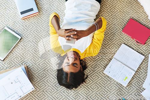 Image of Checking my social media before getting back to studying. High angle shot of a young female student using a cellphone while studying at home.