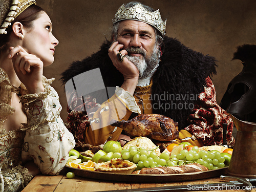 Image of Royal life can be tedious.... A bored queen sitting alongside her husband at a banquet.